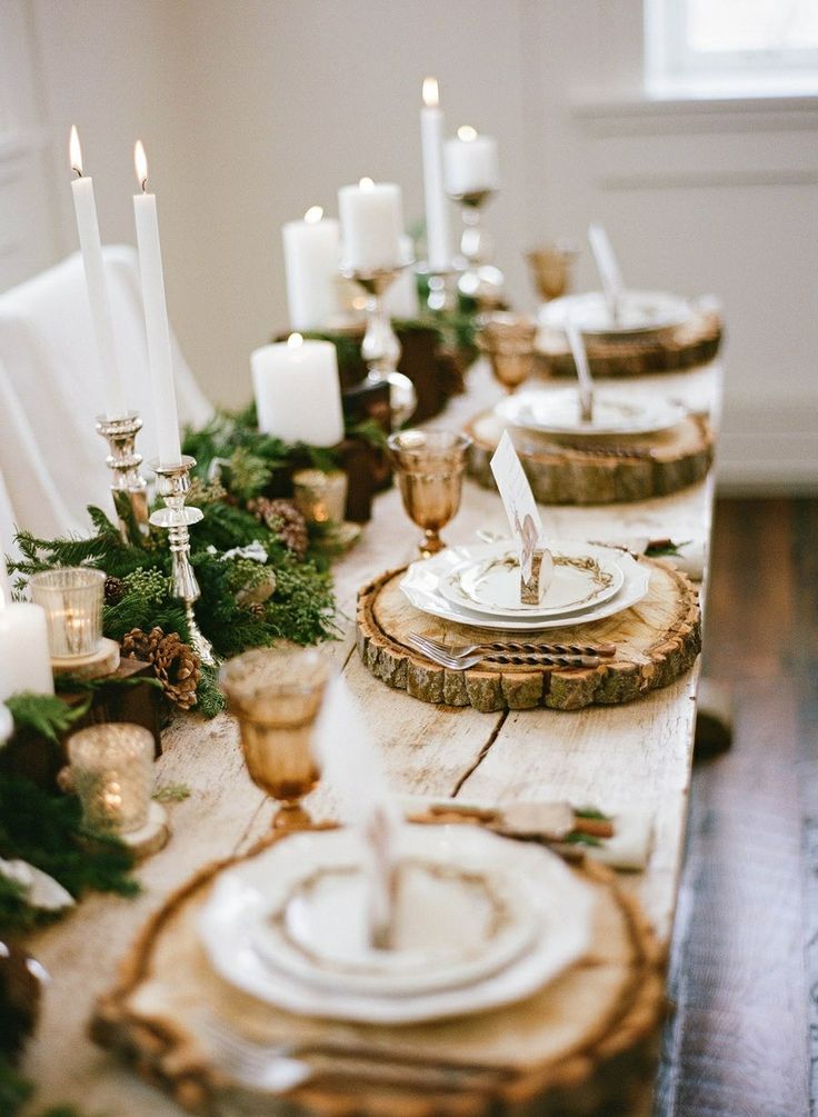 Christmas table with white candles and white dishes and wooden tray