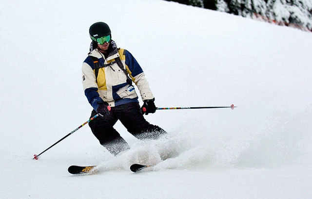 ski man with black ski pants and green mask