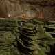 Hang Son Doong explorers navigate an algae-covered cavescape.