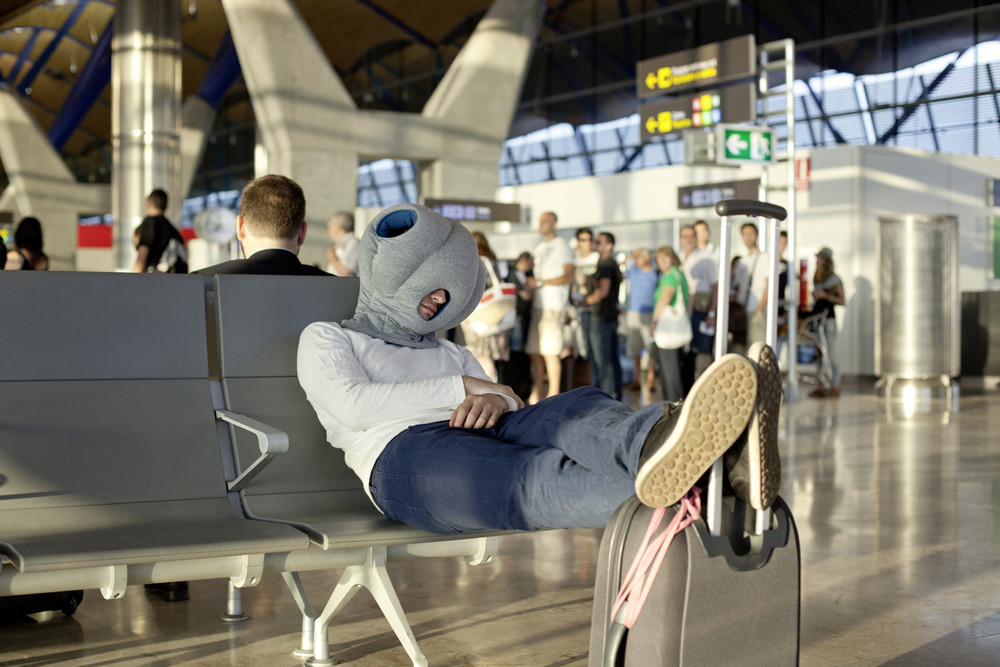 ostrich-pillow man sleeping on the airport