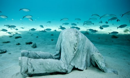 Underwater sculpture park, Grenada A man with head in the sand underwater