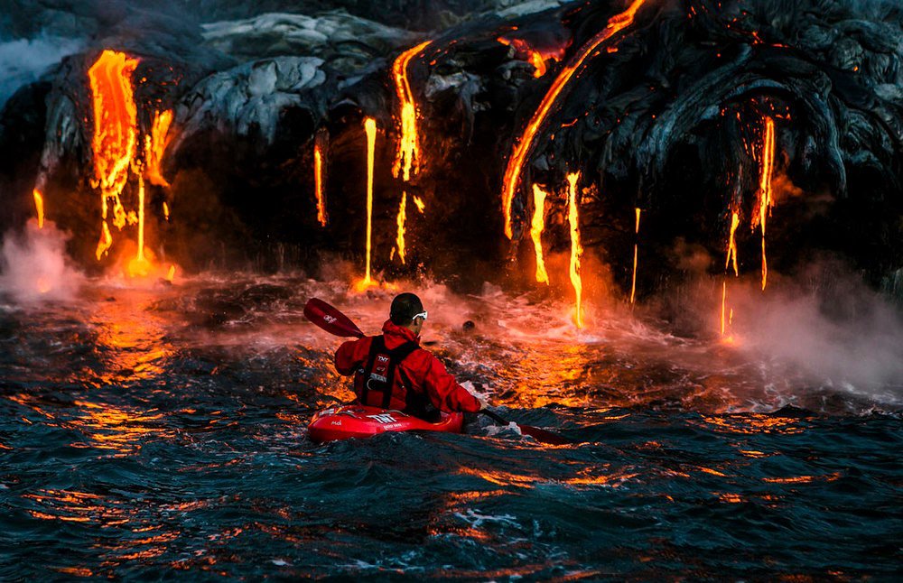 active volcano man sealing on kayak among lava