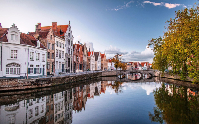 Fall-in-Belgium,-Bruges-top-fall-travel-destinations-beautiful-river-reflects-autumn-colors-perfect-picture-romantic-town-old-buildings