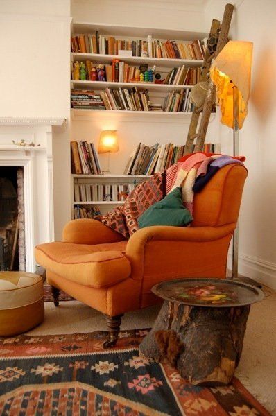 cozy reading chair orange fireplace wooden table colorful carpet white nook