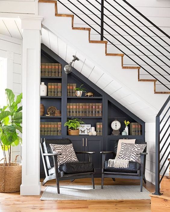 cozy reading nook under tha stairs with two chairs