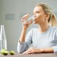Woman-drinking-cup-of-water-limes-on-the-table