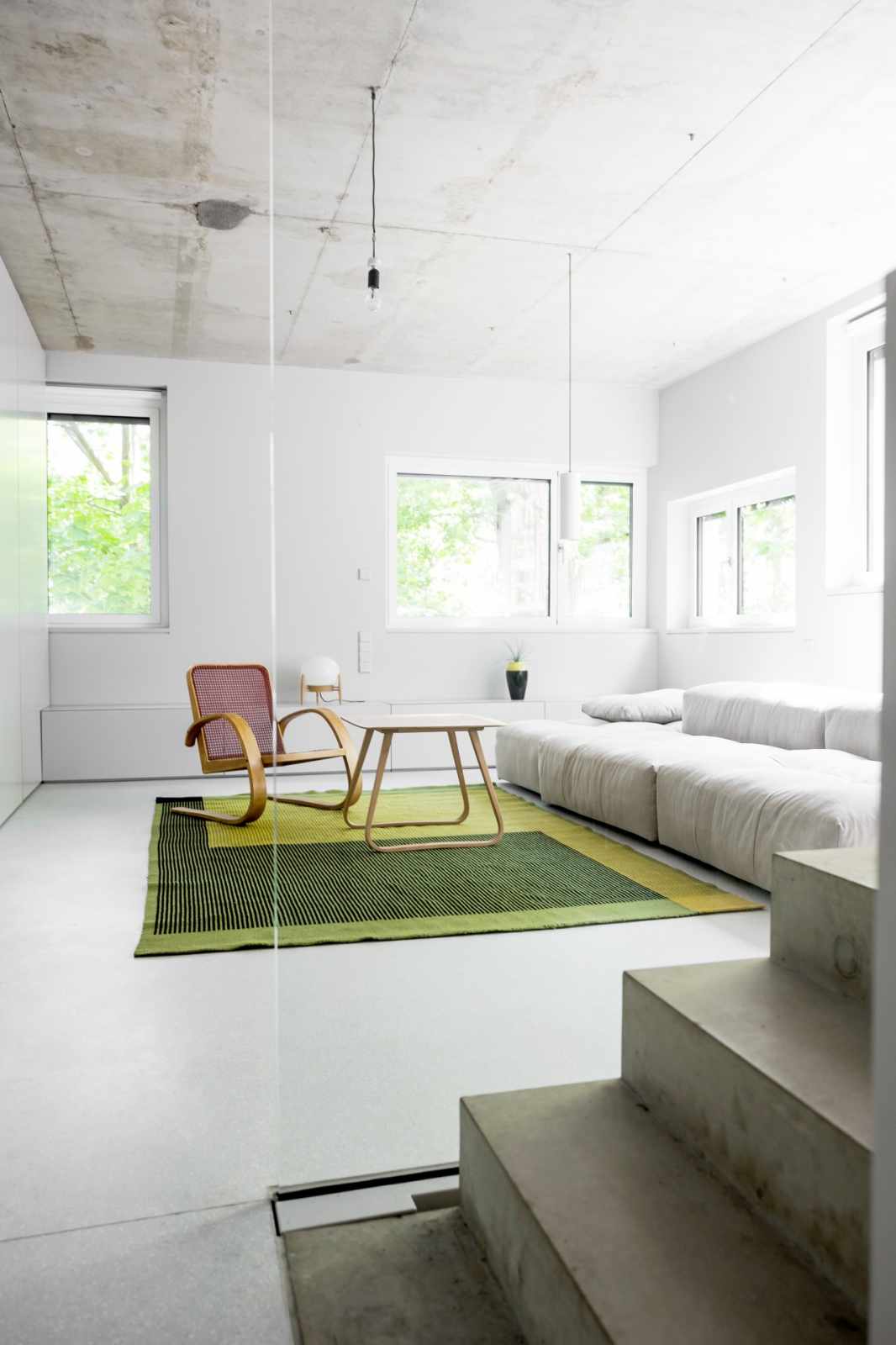 Minimalist Living Room with Green Rug and Grey Walls