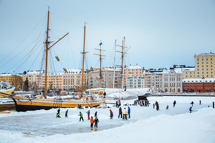 Children ice skating on frozen water in Helsinki port 