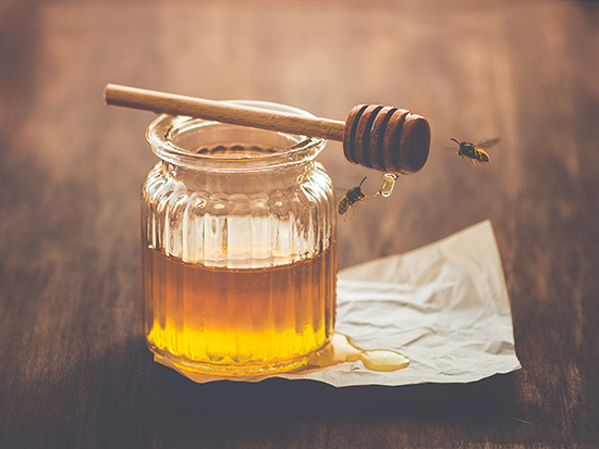 Honey in a jar with bees around 