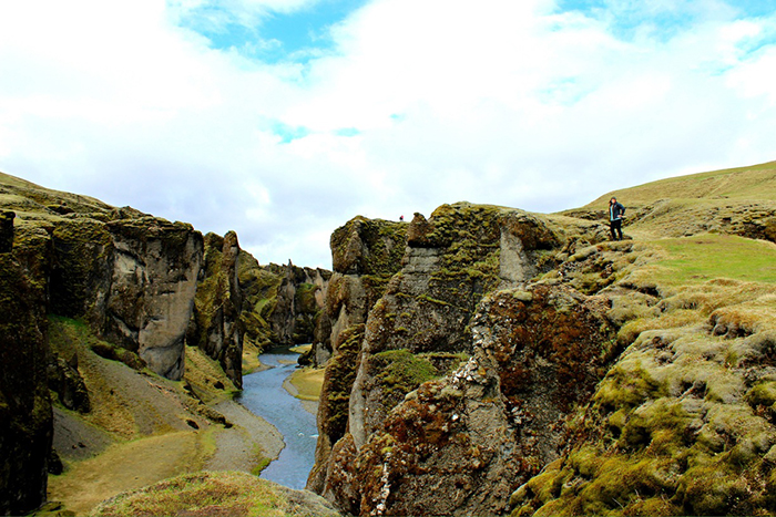 Woman standing on a rock from ring road in Iceland 