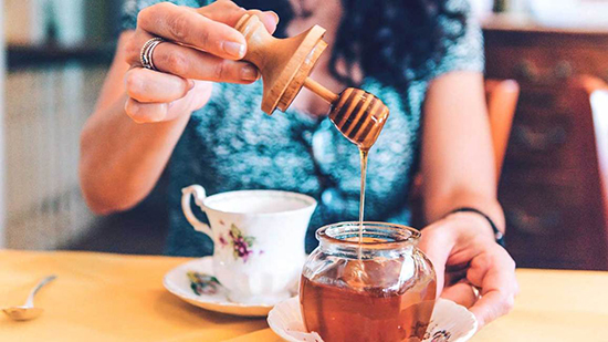 Woman drinking tea with honey