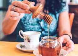 Woman puts honey in her tea