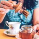 Woman puts honey in her tea