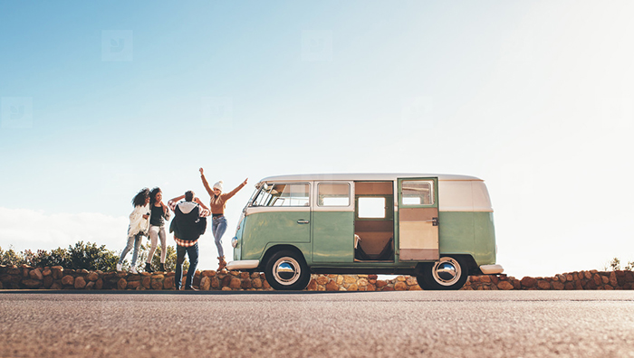 Friends with retro bus having road trip 