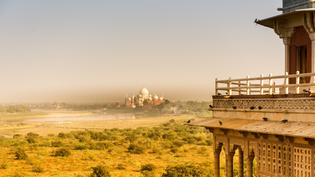 View on a meadow and Taj Mahal in India