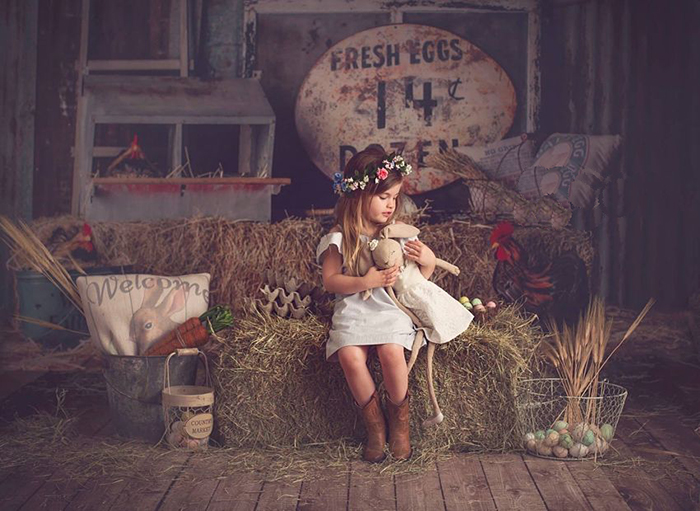 Little girl with floral diadem and holding her teddy