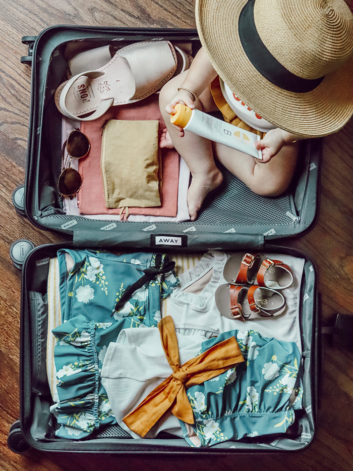 Baby sitting on a full luggage