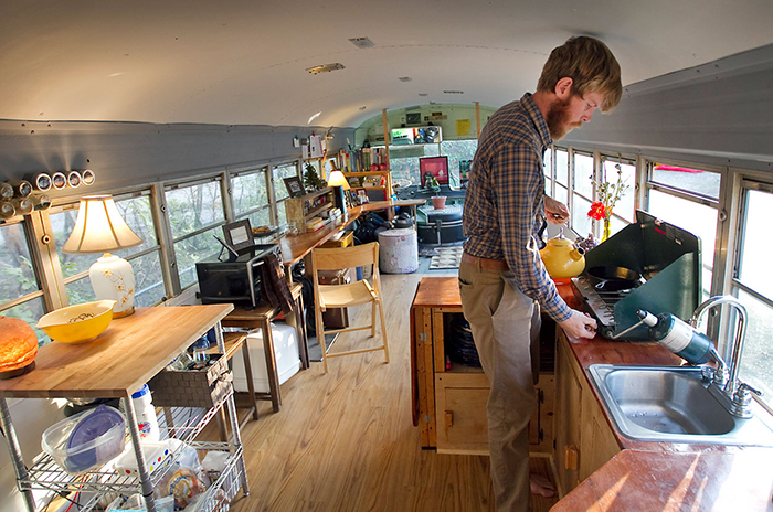 Man cooking in tiny house on wheels