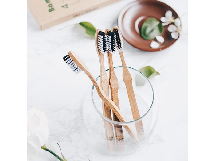 Reusable bamboo toothbrushes in a glass