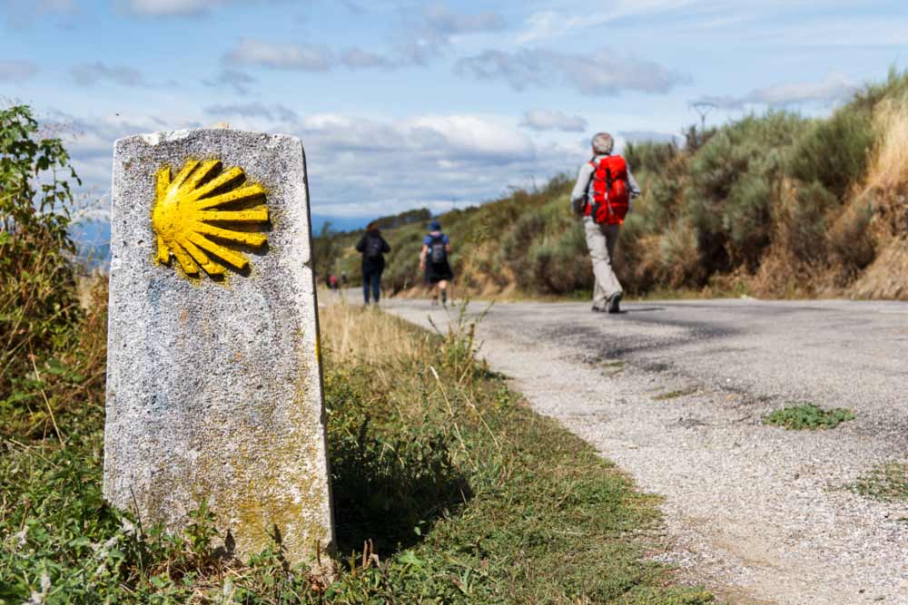 Pilgrims and a waymark showing the way