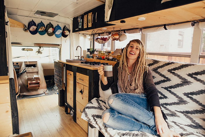 Girl drinking coffee in a small house on wheels