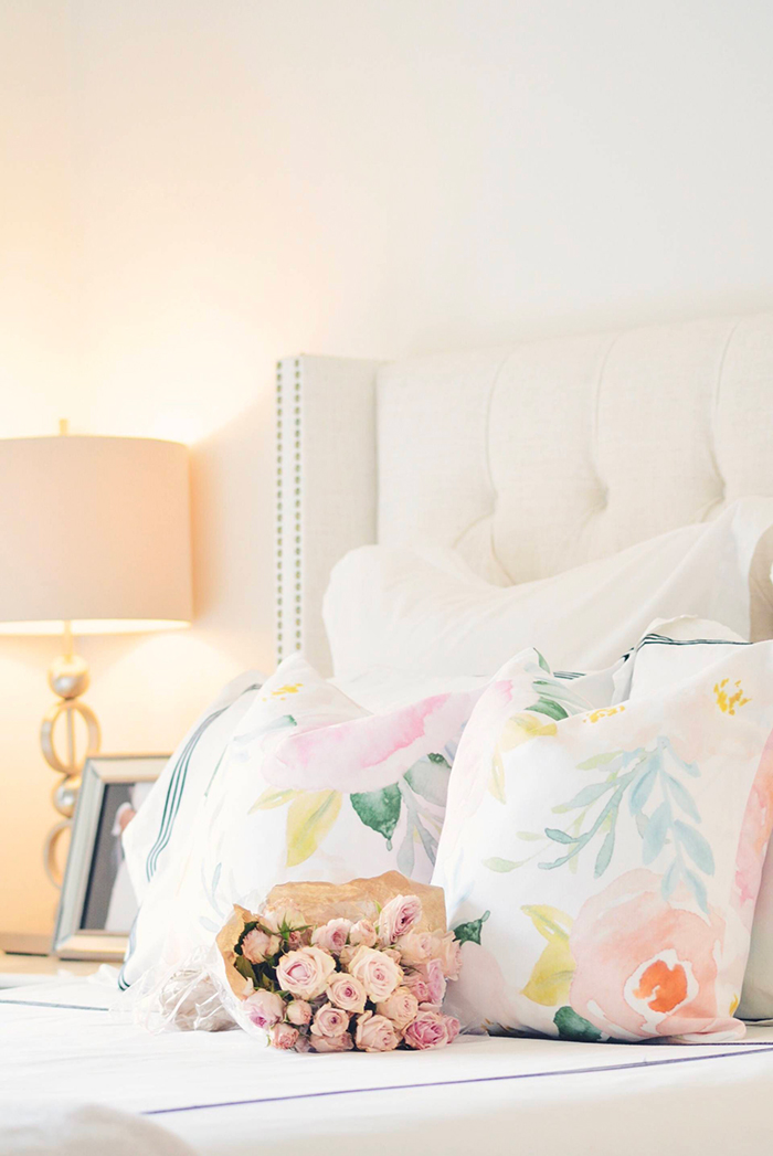 Floral pillows on bed with roses 