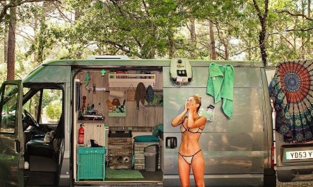 Woman taking a shower in front of her tiny house on wheels