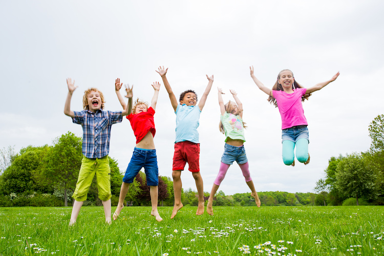 Happy kids jumping outdoors