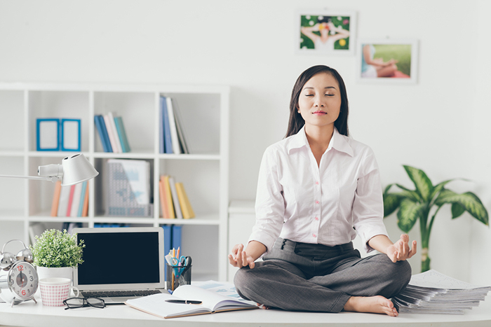 Woman doing yoga at her work place