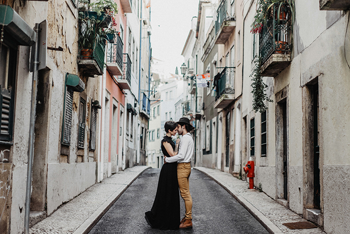 Couple hugging in a cozy and empty street in Lisbon