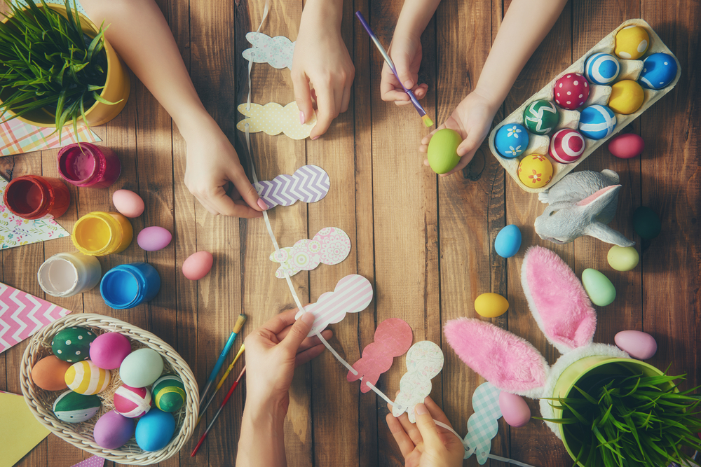 Kids coloring Easter eggs and doing Easter paper crafts in the form of humans