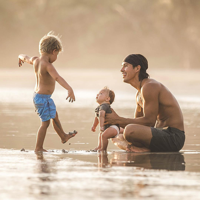 Father and two kids playing at the beach