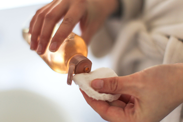 Woman putting face toner on a cotton pad