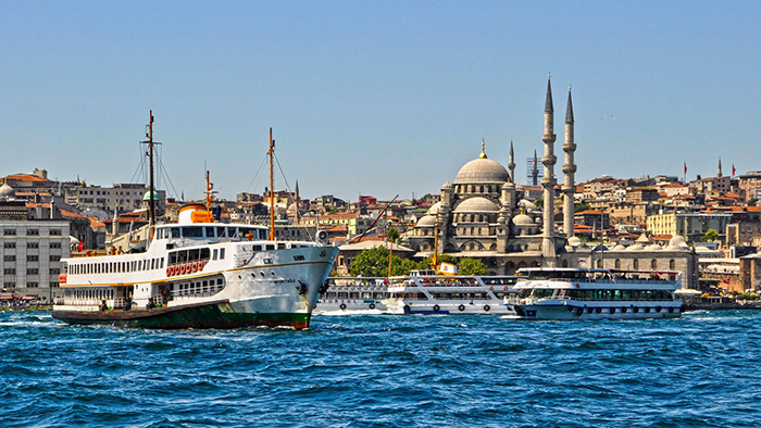 Boats on the sea and mosques behind them