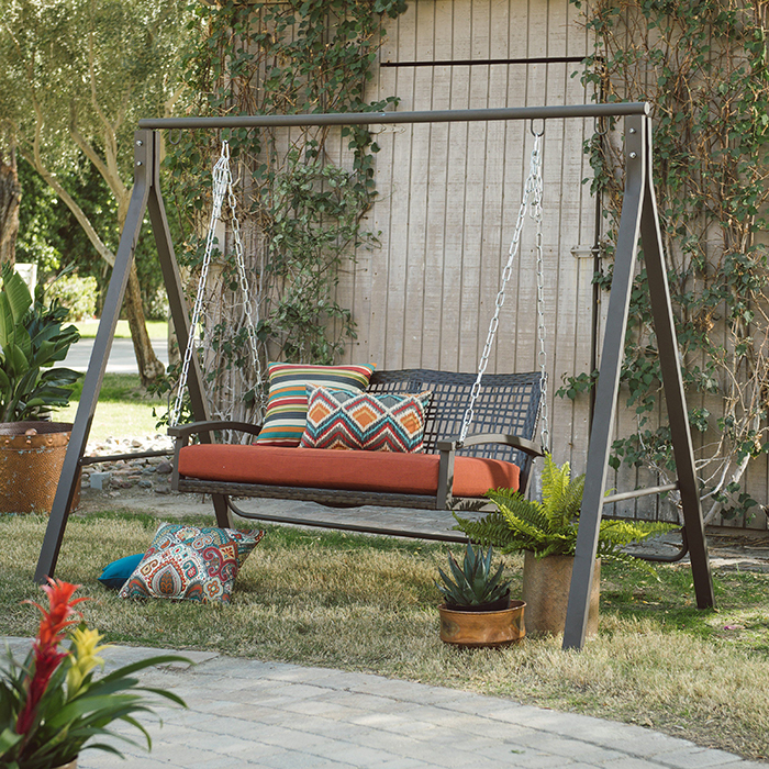 Outdoor metal porch swing with colorful cushions on it