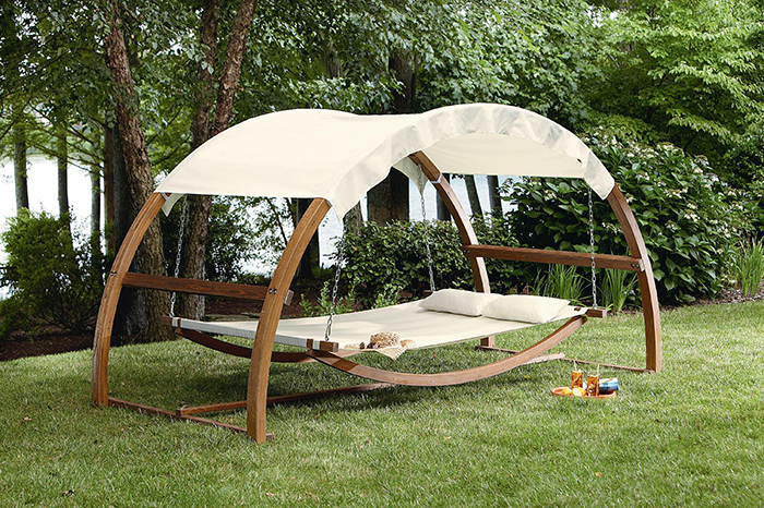 Swing with canopy placed at the patio and surrounded with good nature