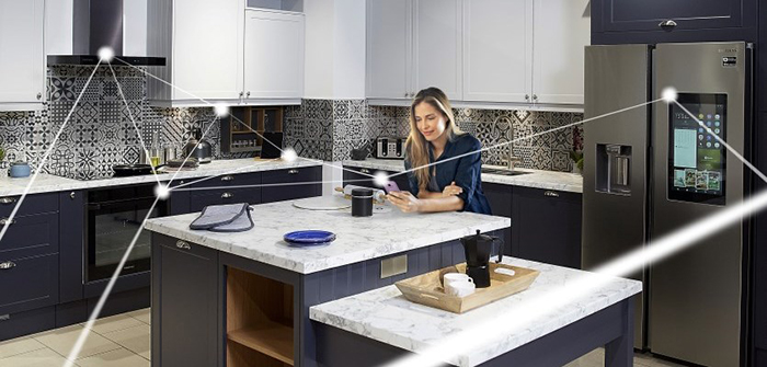 Woman standing in a smart kitchen and controlling the cooking process through her smartphone