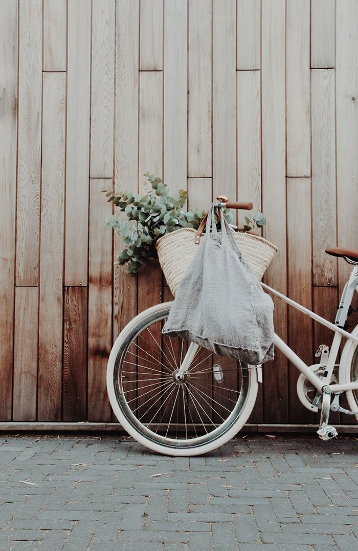 Vintage bike put near to a wooden wall and sustainable grocery bag on it 