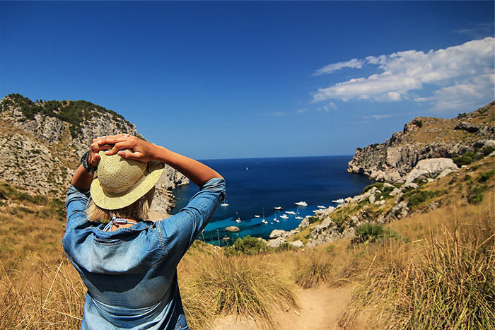 Woman with hands on the head enjoying a nice view on the sea