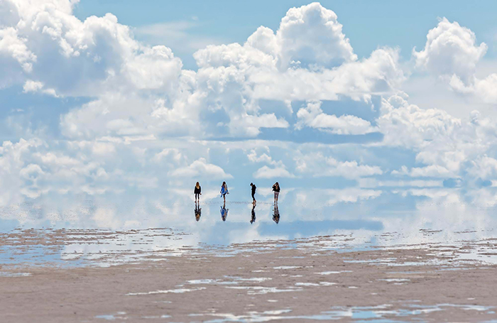 People having a walk on the beach and a clean sky