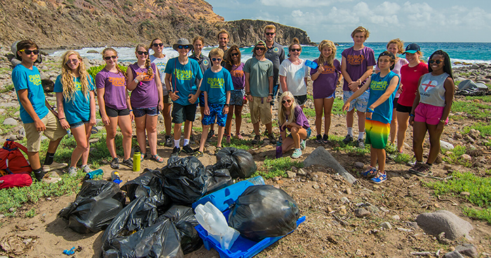 Young volunteers cleaning the beach from plastic