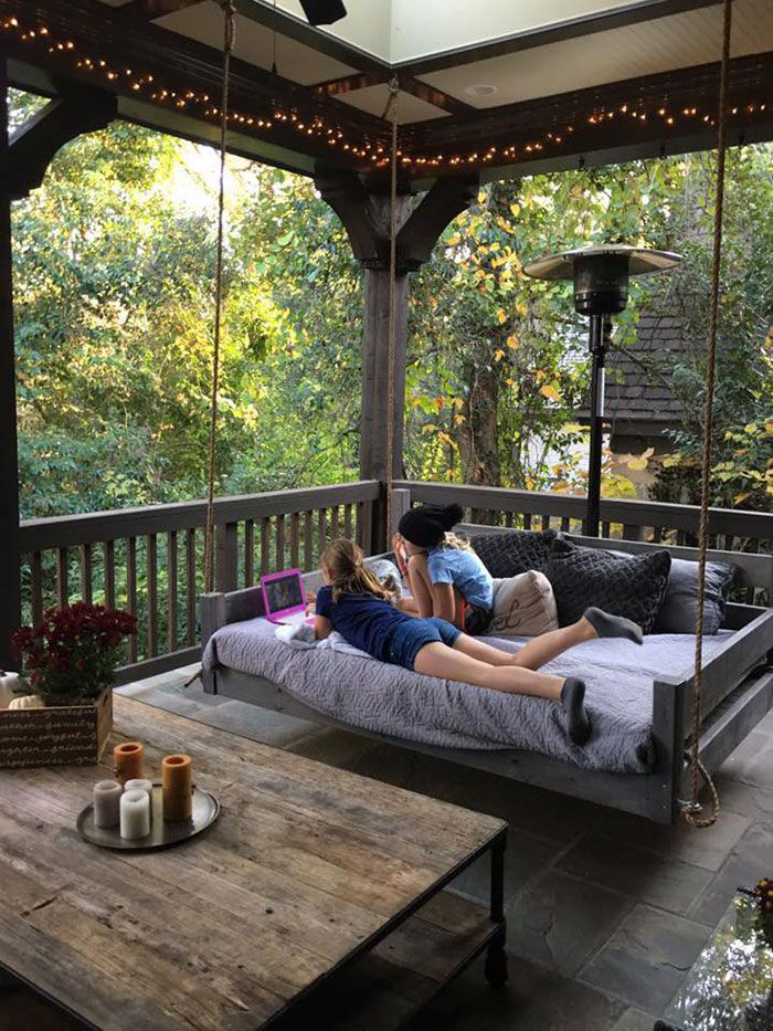 Two girls chilling at their wooden porch in the house balcony