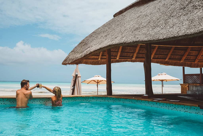 Couple enjoying at the outdoor pool of an luxury hotel 