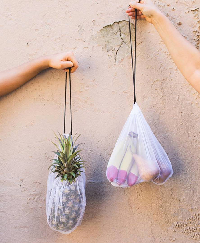 Two persons holding plastic free bags