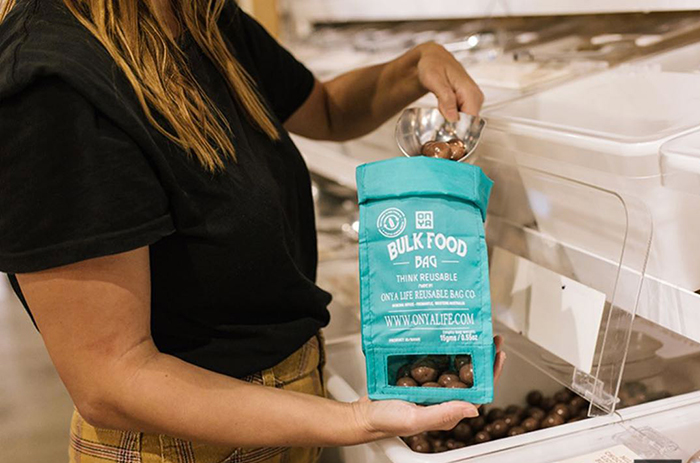 Woman filling a plastic free pack at the grocery store