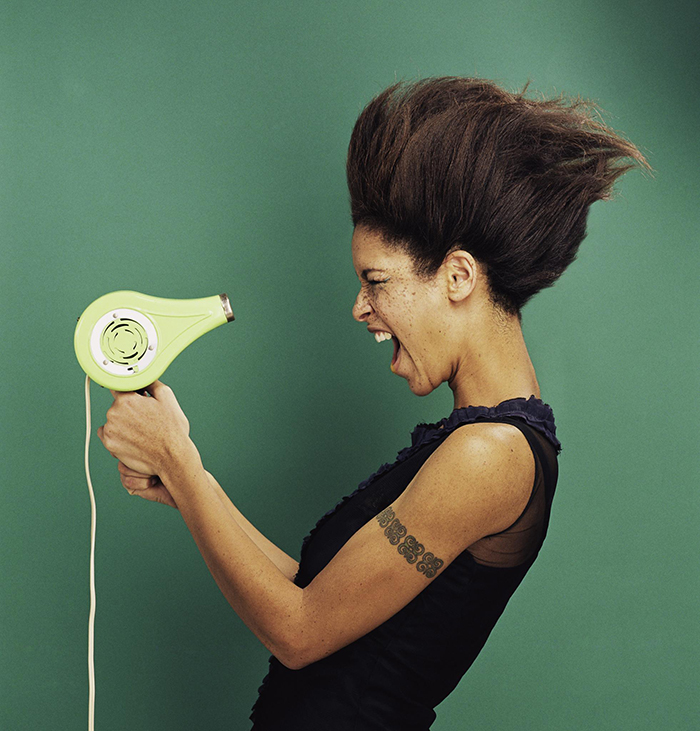 Woman with green hair dryer blowing her hair hair care tips