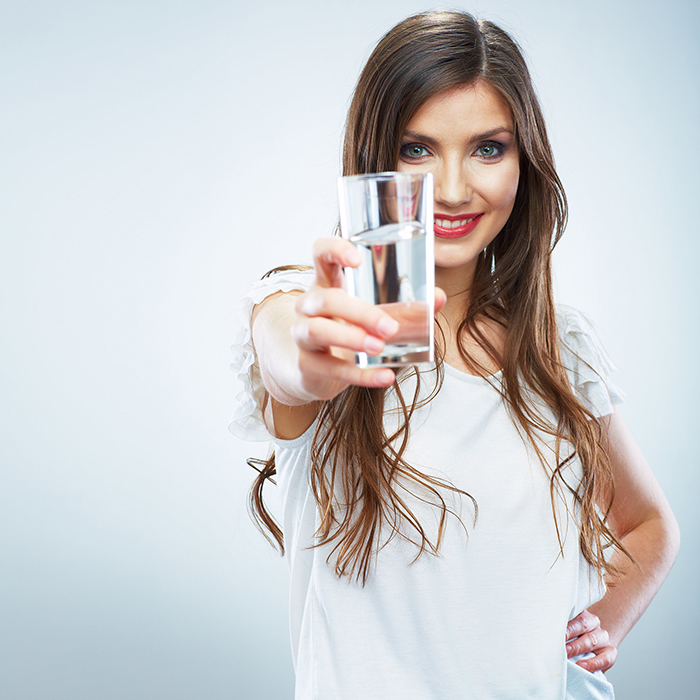 Beautiful woman with long hair with water in her hand