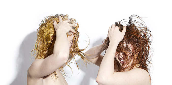 Two women shampooing their hairs and having fun