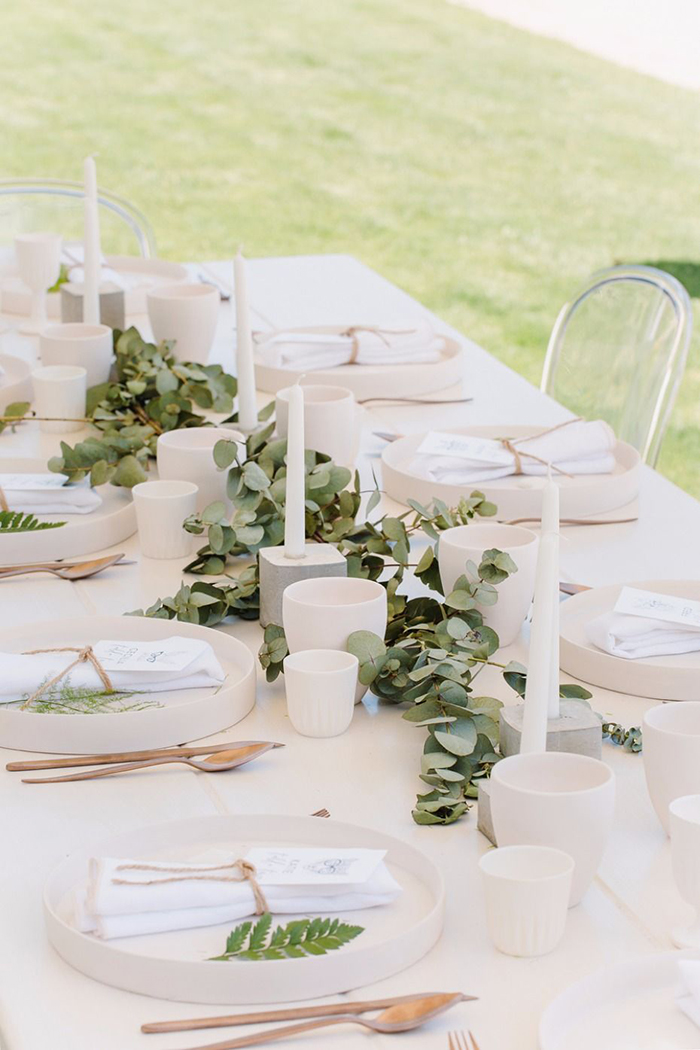 Candles with leaves around them on the wedding table