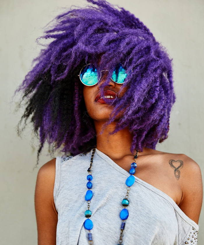 Afro american woman with purple hair and blue sunglasses